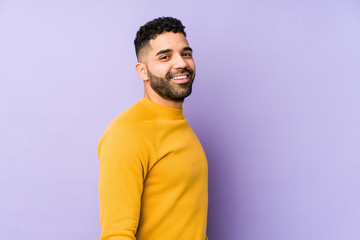 Young mixed race arabic man isolated looks aside smiling, cheerful and pleasant.