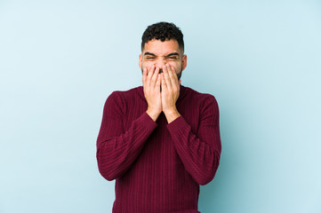 Young mixed race arabic man isolated laughing about something, covering mouth with hands.
