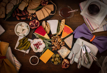 Cheese, crackers and pickles assortment on wooden table