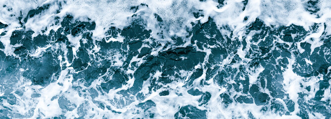 Aerial view of salt ocean waves. Blue water aqua sea background ot texture. Rippled spashing waves wide banner panoramatic photo.