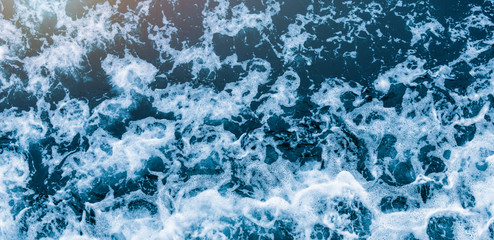 Background shot of aqua sea water waves surface. Blue ocean water and foam aerial or drone photo.