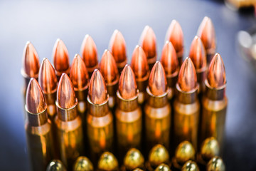 Various kind of bullets or ammonution on dark stone table. Bullet pile in color background. Magazines, rounds and ammo military technology..