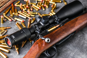 Close up of rifle scope hunting on wooden ammonition background. Hunt sniper gun, optics scopes...