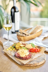 Roasted octopus BBQ and Baked potato with a glass of Grapa. Wooden plate. Restaurant menu