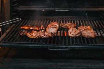 Mouth-watering beef steaks being cooked over a charcoal pan