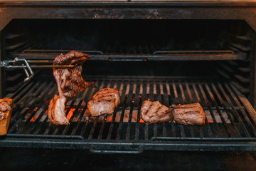 Tenderloin steaks being cooked over a charcoal grill