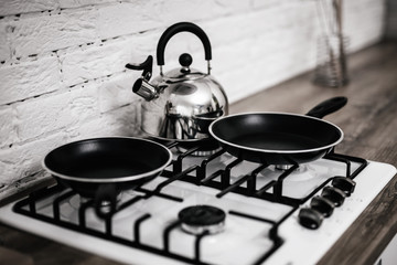 clean stove with two pans and a kettle