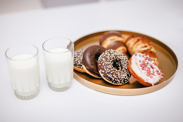 sweet cakes and sweets with dough, next to it there are two glasses of milk