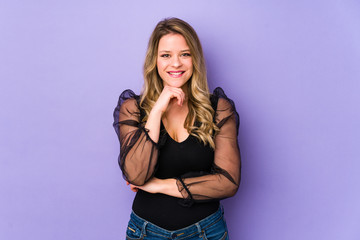Fototapeta premium Young caucasian woman isolated on purple background smiling happy and confident, touching chin with hand.