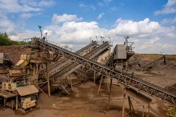 View of open-pit mine machinery with sifters and belt conveyors in basalt quarry