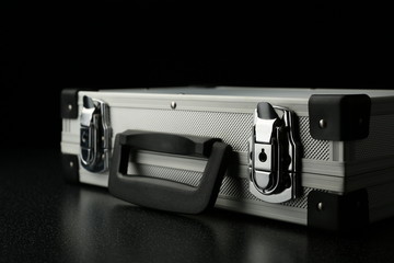 aluminum suitcase on a black background. stylish aluminum case on a dark background