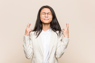 Young business chinese woman crossing fingers for having luck