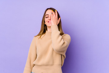 Young caucasian woman isolated on purple background laughing happy, carefree, natural emotion.