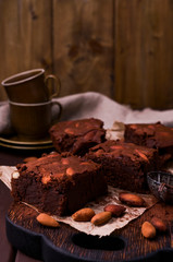 Brownie, Chocolate cakes with almonds on a wooden board, sprinkled with cocoa. Served homemade cakes. Top view. Free space for text.