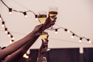 Cheers! Group of people cheering with champagne flutes with party background, Concept Celebration.