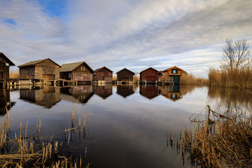 Fototapeta premium Neusiedler See, Lake Neusiedl. Bay with wooden pier and wooden cottage.