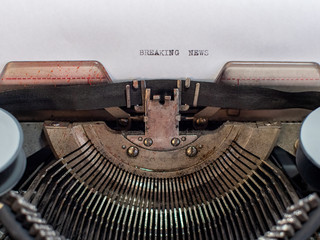 close-up text BREAKING NEWS. old vintage typewriter with a sheet of white paper
