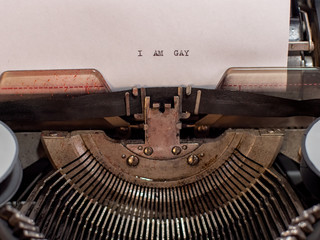 close-up text I AM GAY. old vintage typewriter with a sheet of white paper
