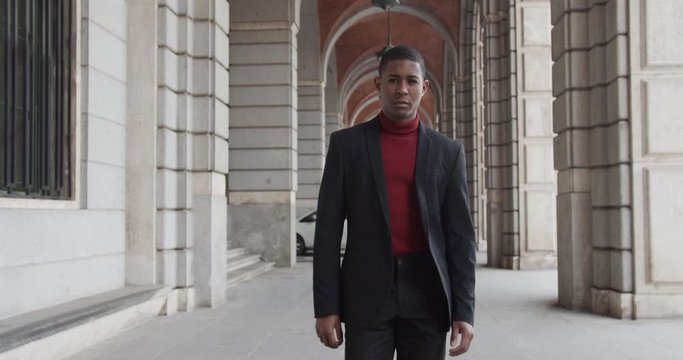 attractive black Hispanic young guy male businessman successful manager in a classic suit follows the camera
