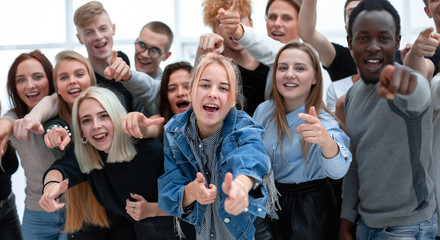 group of cheerful young people pointing at you