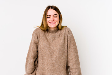 Young caucasian woman isolated on white background laughs and closes eyes, feels relaxed and happy.