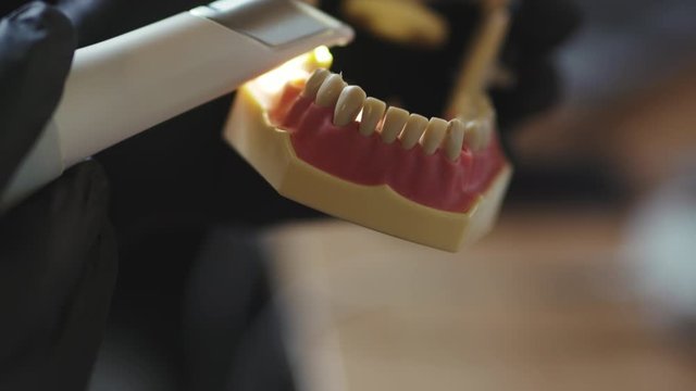 Dental care. Close-up of dental technician in laboratory working on dentures fake teeth for customer. Production of new dental implants. Removable jaw.
