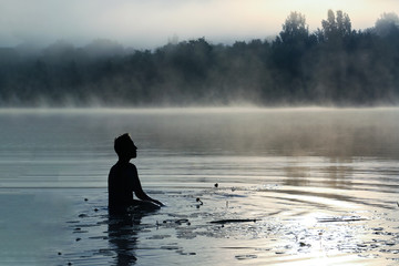 The woman on the lake, at dawn in the fog.