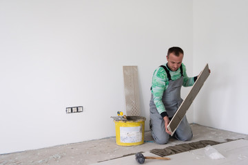 worker installing the ceramic wood effect tiles on the floor
