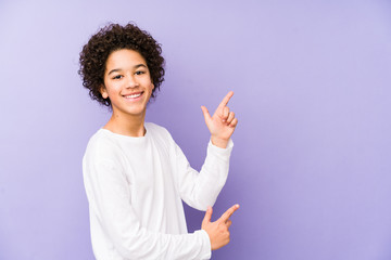 African american little boy isolated pointing with forefingers to a copy space, expressing excitement and desire. © Asier