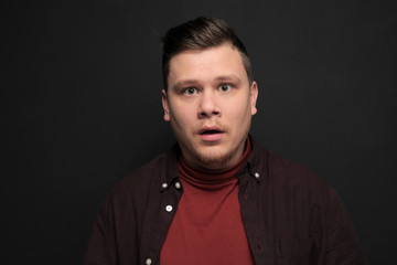 Obraz premium Portrait of young scared man isolated on gray background