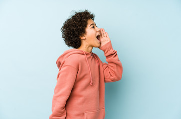 African american little boy isolated shouting and holding palm near opened mouth.