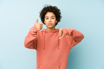 African american little boy isolated showing thumbs up and thumbs down, difficult choose concept