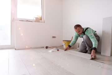 worker installing the ceramic wood effect tiles on the floor