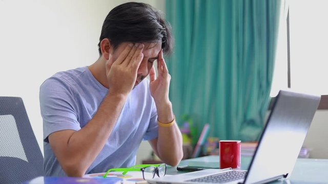 Asian businessmen having a headache in front of laptop ,Healthcare And Medicine concept, Office syndrome