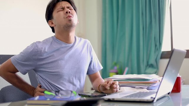 freelance man with have back pain in office . Pain relief concept