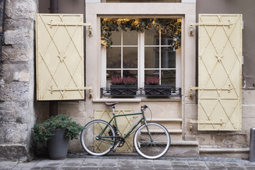 Fototapeta na wymiar classic bicycle standing near beautiful window on the street in europe