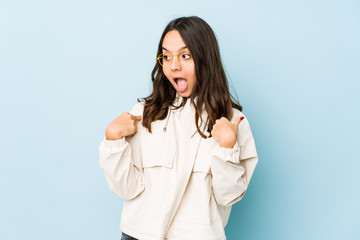 Young mixed race hispanic woman isolated surprised pointing with finger, smiling broadly.