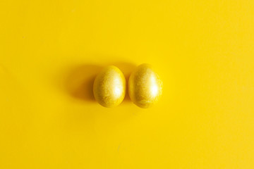 Golden testicles. Easter eggs on yellow. Two eggs on yellow background