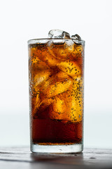 cola drink with ice in glass on wood table