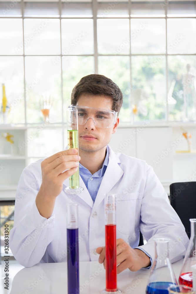 Poster A male scientist working in a science lab with various equipment in the lab
