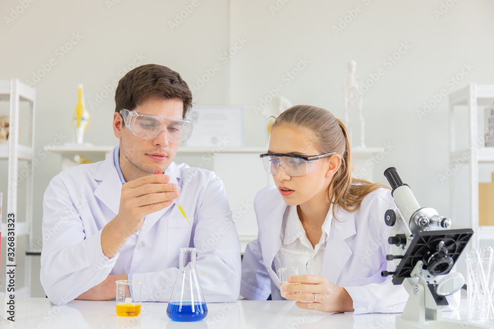 Poster male and female scientists working in a science laboratory with various equipment in the laboratory.