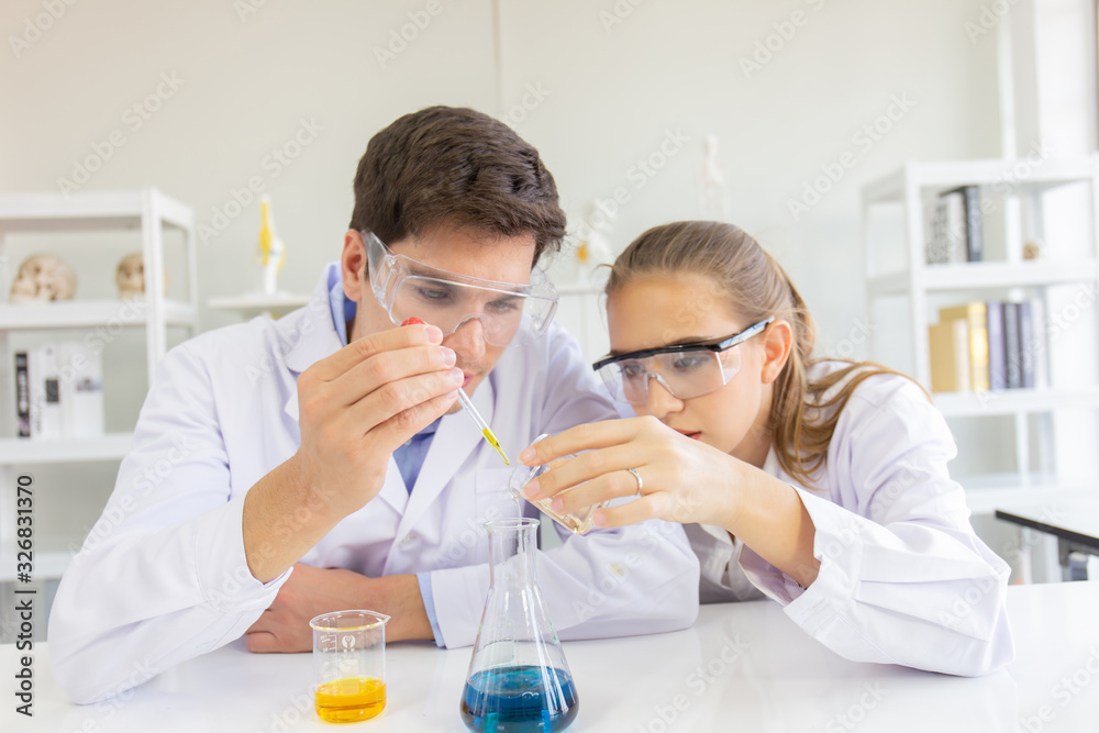 Poster male and female scientists working in a science laboratory with various equipment in the laboratory.