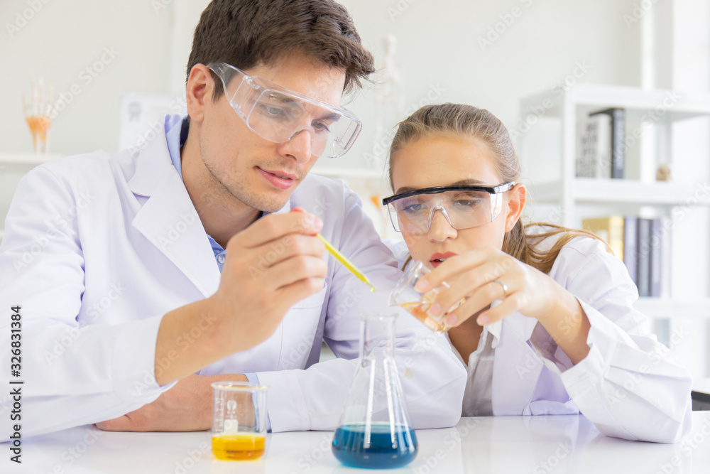Poster male and female scientists working in a science laboratory with various equipment in the laboratory.