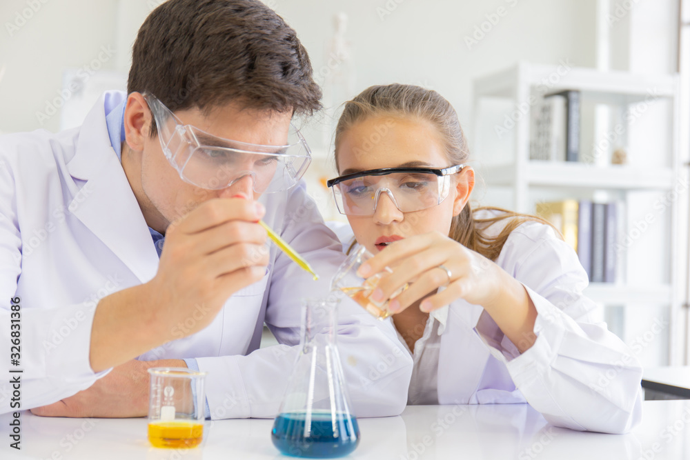 Poster male and female scientists working in a science laboratory with various equipment in the laboratory.