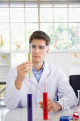 A male scientist working in a science lab with various equipment in the lab