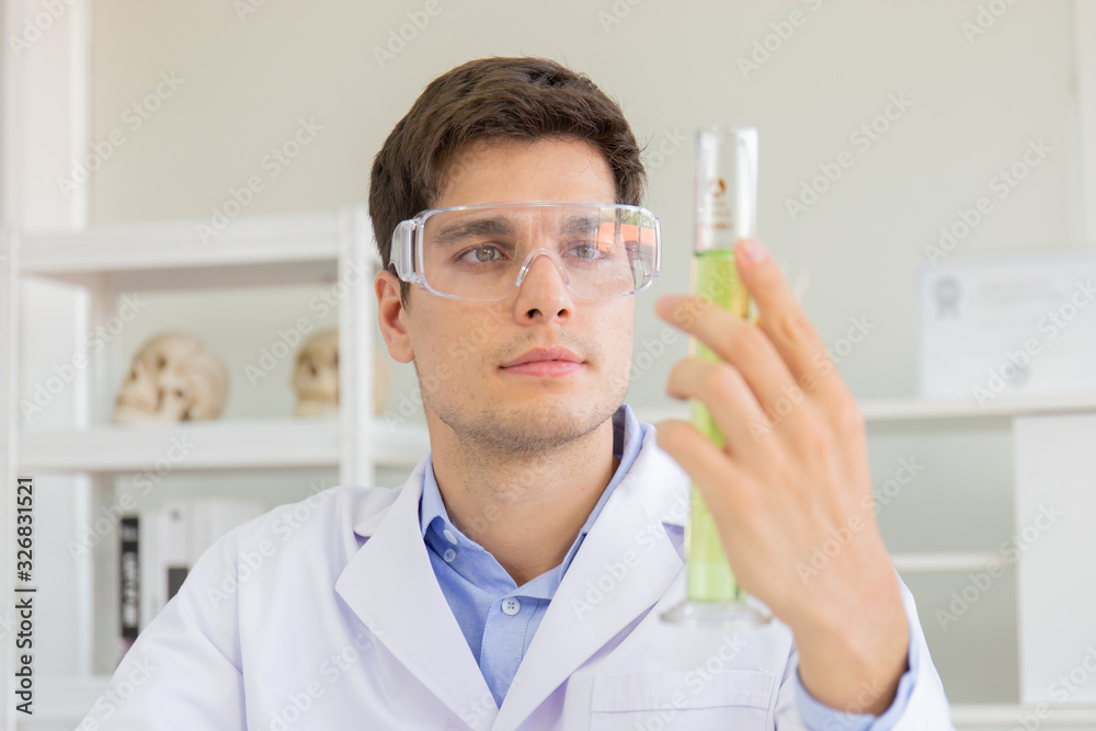 Poster A male scientist working in a science lab with various equipment in the lab