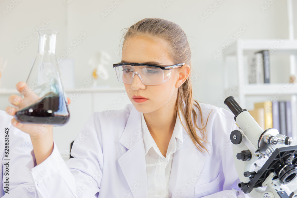 Poster A beautiful female scientist is operating in a science lab with various equipment in the lab.