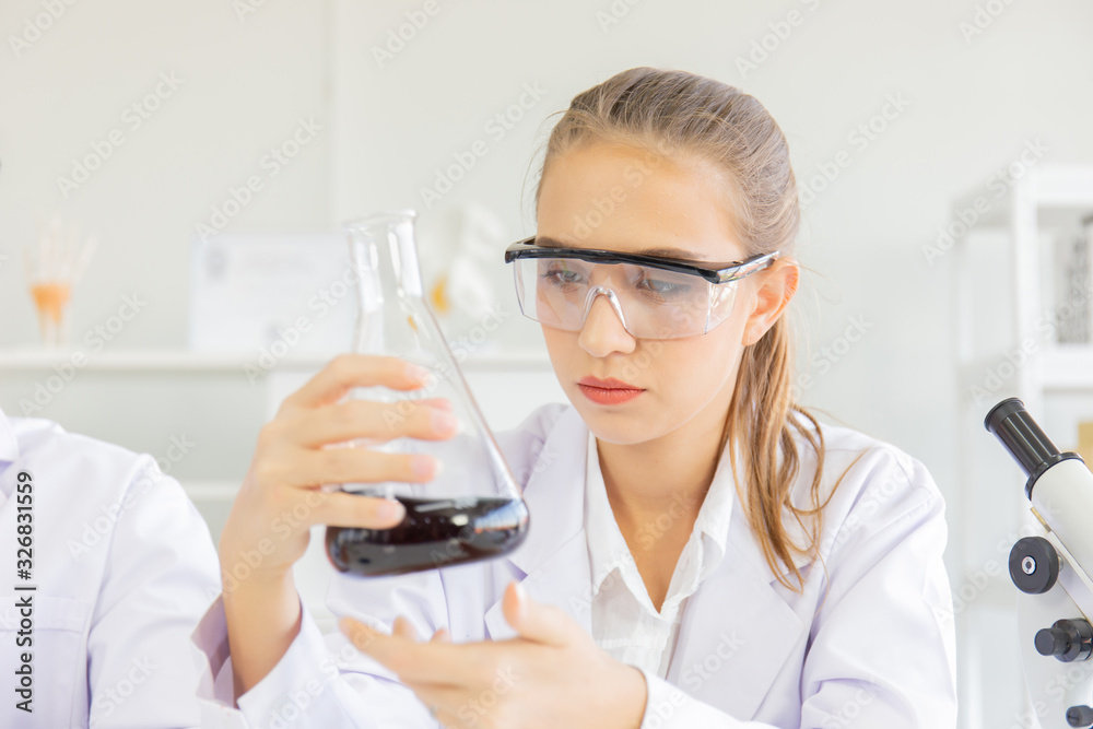 Poster A beautiful female scientist is operating in a science lab with various equipment in the lab.