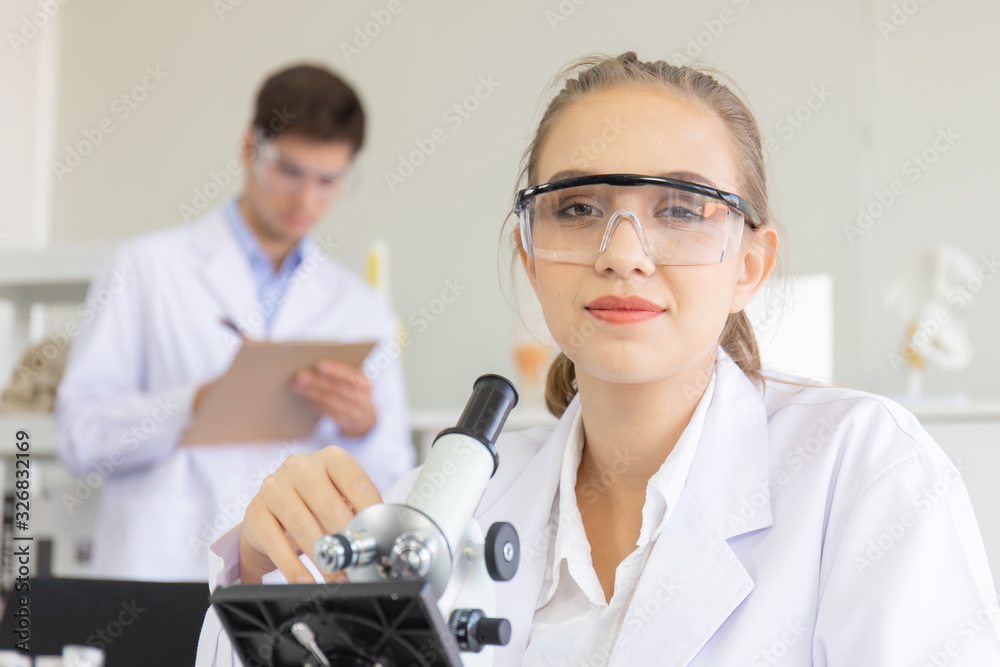 Poster The concept of a new generation of scientific researchers looking through a microscope in a laboratory Young scientists are doing research.