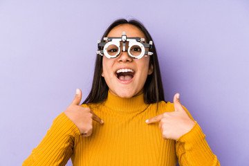 Youn indian woman with optometry glasses surprised pointing at himself, smiling broadly.